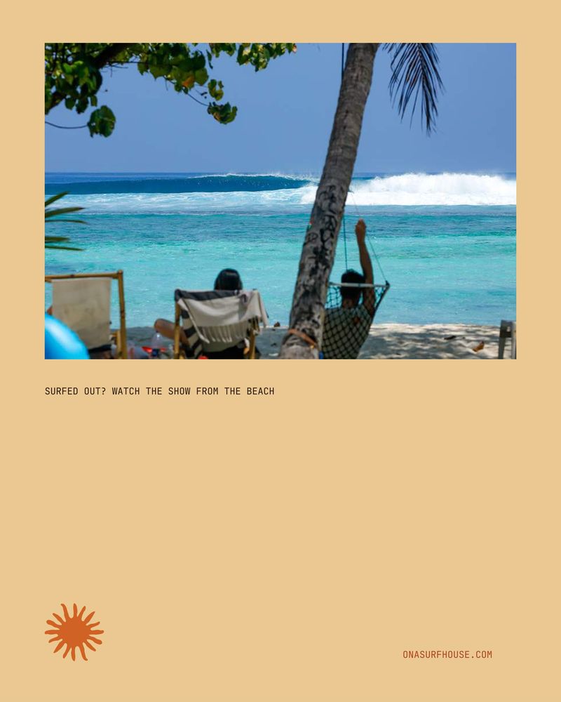 Surfers resting in chairs on the beach watching a wave peel